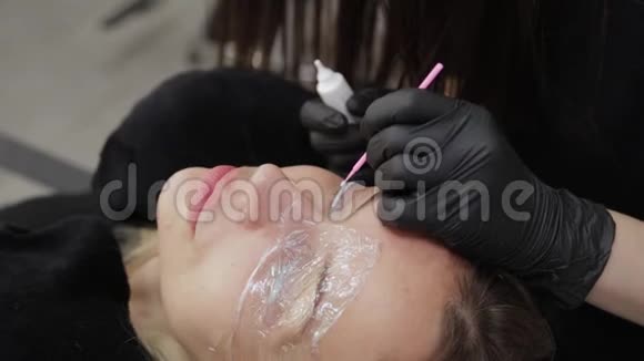 一家美容院的专业美容师用一种特殊的凝胶将睫毛层压到睫毛上视频的预览图