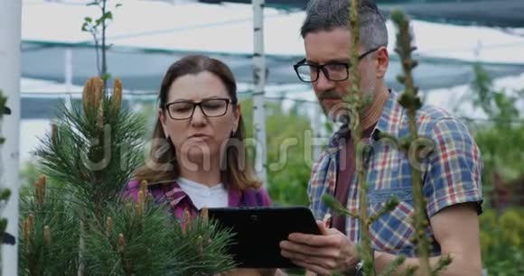 两位园丁在苗圃里用平板电脑视频的预览图
