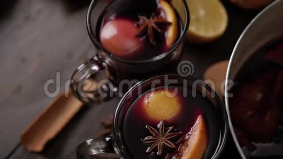 两个玻璃杯的顶部视图与覆盖葡萄酒在棕色木制背景在葡萄藤表面上的八角星和切片视频的预览图