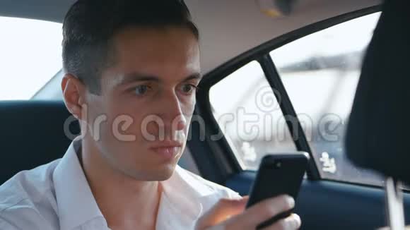 当他乘出租车时商人被他在智能手机上读到的坏信息所震惊休克和视频的预览图