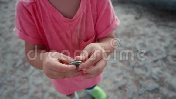 孩子手中的铁圆硬币视频的预览图