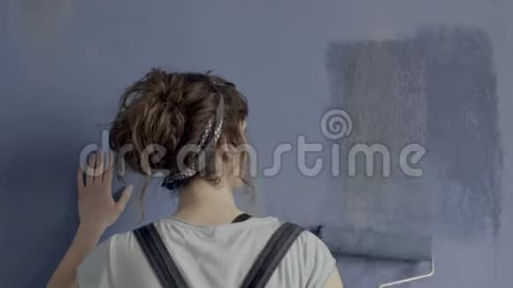 女人在后面用滚筒画墙视频的预览图