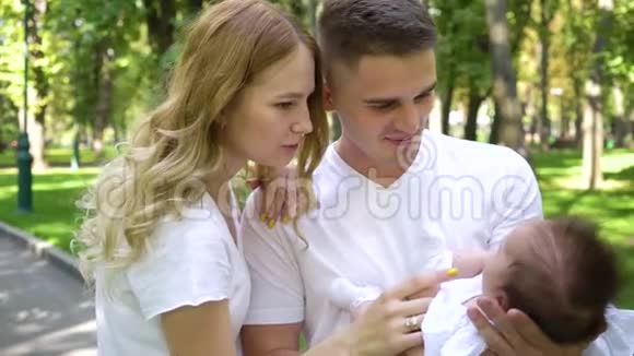 可爱的一家人穿着白色衣服和小女孩在夏天公园视频的预览图