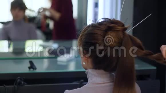 理发师用两根发条组成止血带发型师长着一个时髦的节日发型视频的预览图