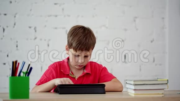 小学生看着平板电脑视频的预览图