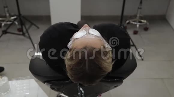 美丽的女人躺在美容院的一个程序上眼睛上有棉花垫视频的预览图