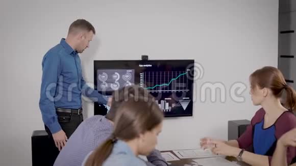 在办公室报到一个人以自己的方式为同事做演讲商业幻灯片显示在电视上视频的预览图