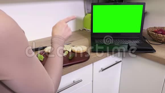 女人在厨房里用绿色屏幕做汉堡视频的预览图