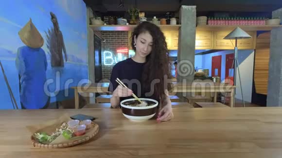 年轻的亚洲女人在咖啡馆拍一张薄煎饼的照片技术和社交网络的概念视频的预览图