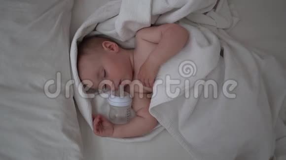 一个可爱的一岁小宝宝嘴边放着一个瓶子慢慢地睡得很香视频的预览图
