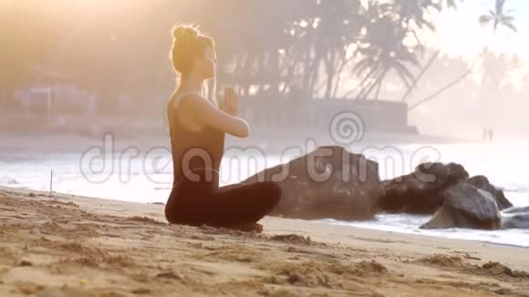 女士在烧香的沙滩上做瑜伽视频的预览图