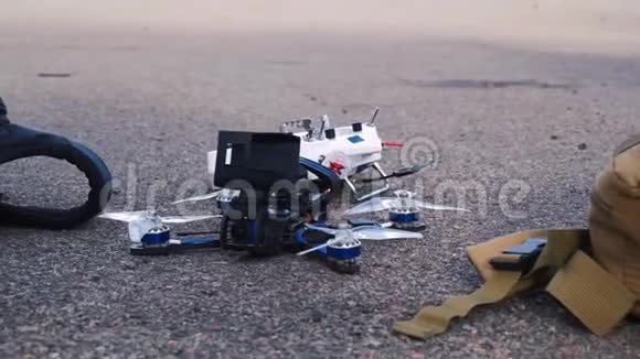 FPV无人驾驶赛车操控者躺在沥青上视频的预览图