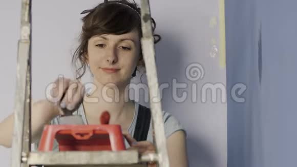 幸福的女人独自装修新房子和粉刷内墙视频的预览图