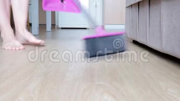 女人用刷子和簸箕打扫厨房的地板视频的预览图