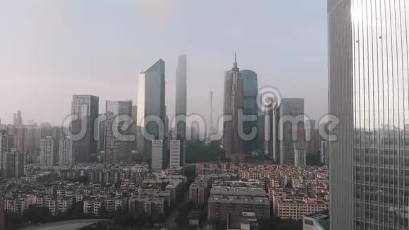 无人机的侧飞在住宅区的框架内摩天大楼和广州塔办公楼广州日出视频的预览图