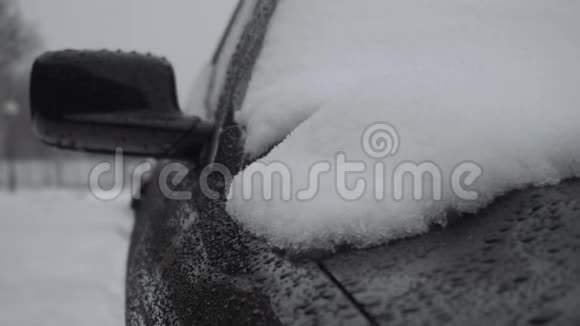 冬天降雪时雪落在汽车引擎盖上恶劣的天气条件交通暴风雪危险视频的预览图