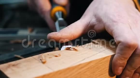 木工行业一名木工用凿子和他的手切割木器上的凹槽视频的预览图