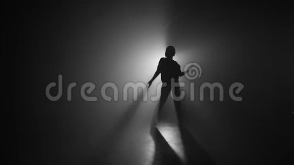 苗条的女人在灯光投影机前的烟雾黑暗舞台上跳舞艺术观念灵活性才女视频的预览图