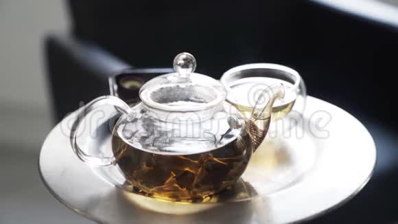 在装有热茶的金属托盘上用茶壶盖上玻璃杯视频的预览图