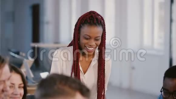 年轻随意积极的非裔美国女性公司老板与合作伙伴交谈微笑着参加混合种族团队会议视频的预览图