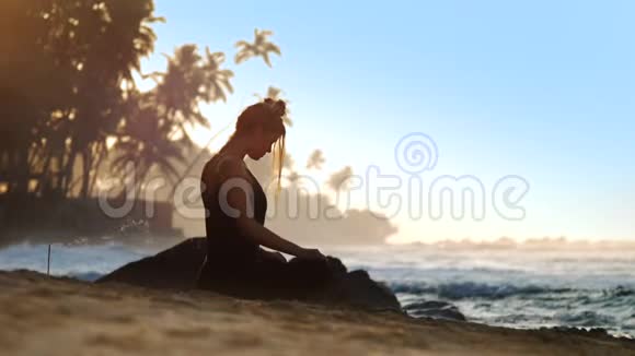 年轻的美女在蓝色的海浪中冥想视频的预览图