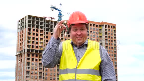 建筑工地上的男建筑工头工人或建筑工头在微笑着拍照时出示新的家庭钥匙视频的预览图