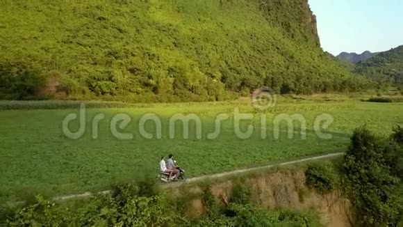 上景人们骑着滑板车沿着田野骑着山视频的预览图