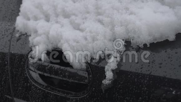 冬天白天下雪时雪落在汽车的门把手上恶劣的天气条件交通暴风雪危险视频的预览图