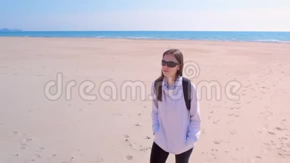 女孩旅行者走在海边沙滩空滩淡季在沙丘度假视频的预览图