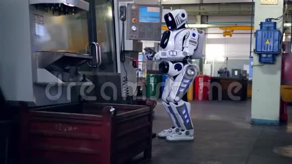 一个机器人在工厂使用平板电脑时检查机器视频的预览图