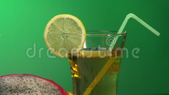 在五颜六色的绿色背景特写火龙果柠檬上装有饮料的玻璃杯视频的预览图