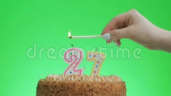 在美味的蛋糕上点燃27岁生日蜡烛绿色的屏幕27视频的预览图