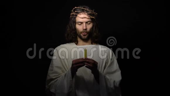 耶稣在荆棘的冠冕上举着蜡烛在黑暗中消失死亡视频的预览图