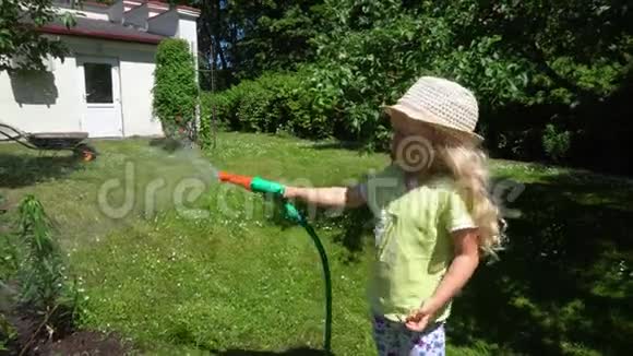 活泼可爱的女孩用洒水车浇灌妈妈花坛万向节运动视频的预览图