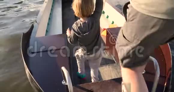男子手牵着孩子在船上行走视频的预览图