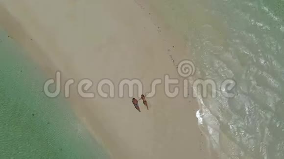 菲律宾巴拉巴茨日落时分一对躺在曼沙兰甘沙洲上的旅行情侣Drone起身视频的预览图