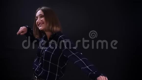 年轻漂亮的短头发女性的特写镜头在镜头前和背景下快乐地跳舞和玩视频的预览图