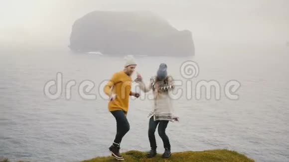 两个疯狂快乐的女人站在海边一起跳舞在冰岛玩的游客视频的预览图
