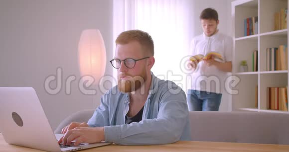 两位白种人成年商人在图书馆合作的特写照片其中一个是在笔记本电脑上打字视频的预览图