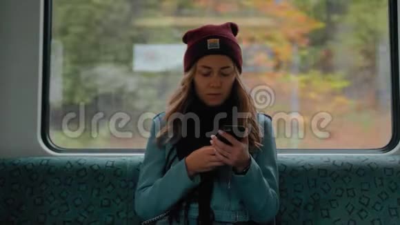 年轻的高加索女孩坐在地铁列车上用电话读信息然后害怕她很害怕她是视频的预览图