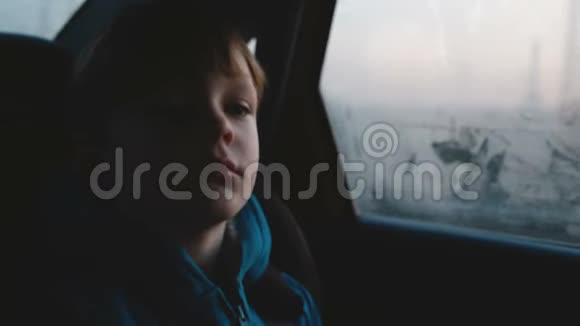 电影拍摄的小36岁可爱悲伤的白种人男孩在黑暗的傍晚乘车时从雾蒙蒙的车窗外看视频的预览图