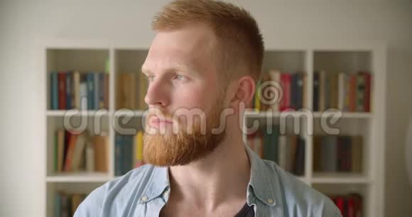 红发胡子白种人男学生在图书馆看镜头的特写镜头视频的预览图