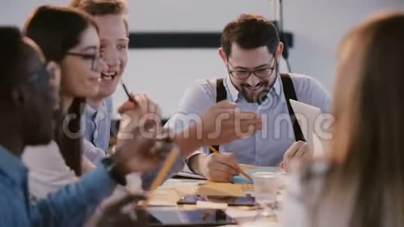 年轻快乐的企业员工在商业研讨会上在现代办公桌边聊天微笑健康的工作场所视频的预览图