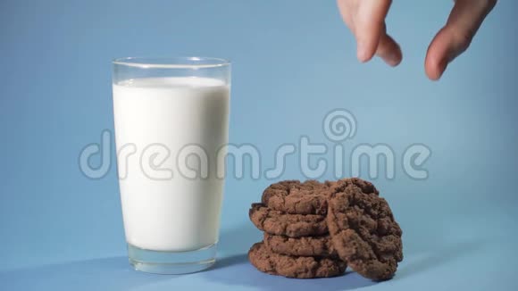 女人把巧克力饼干放进一个带牛奶的杯子里视频的预览图