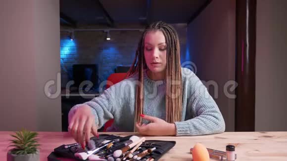 年轻迷人的女化妆师的特写镜头用恐怖片流媒体直播和广告化妆品与恐怖片视频的预览图