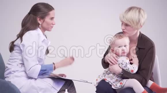 妈妈在医生预约给孩子喂奶儿科医生做笔记视频的预览图