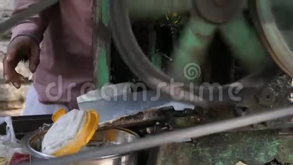 印度工人在印度的小型农村糖厂用甘蔗榨果汁视频的预览图