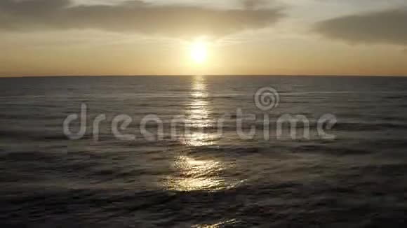 海岸外的海浪拍打着日落后的阳光小径视频的预览图