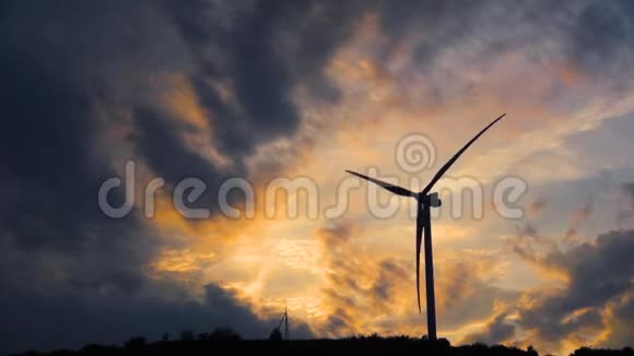 一个单一的风力涡轮机围绕着能源生产背景是暗黄色的天空视频的预览图