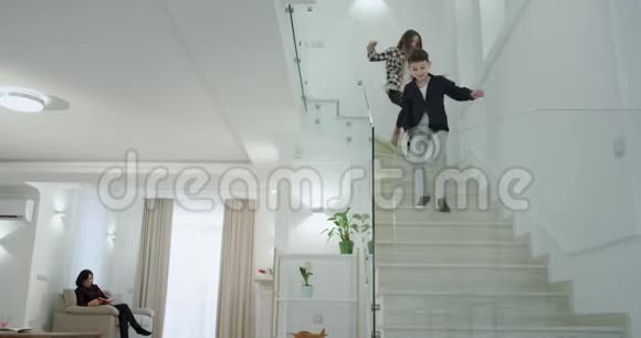 在一个现代化的房子里有一个大的生活和白色的楼梯两个孩子早上跑到一楼去视频的预览图